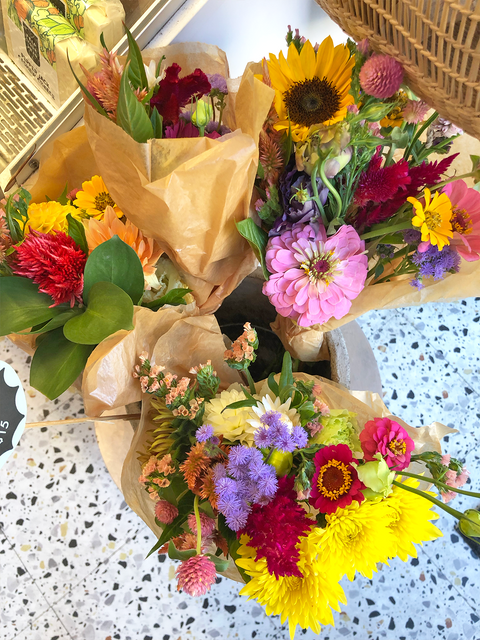 Colorful flower bouquets displayed on a speckled terrazzo floor.