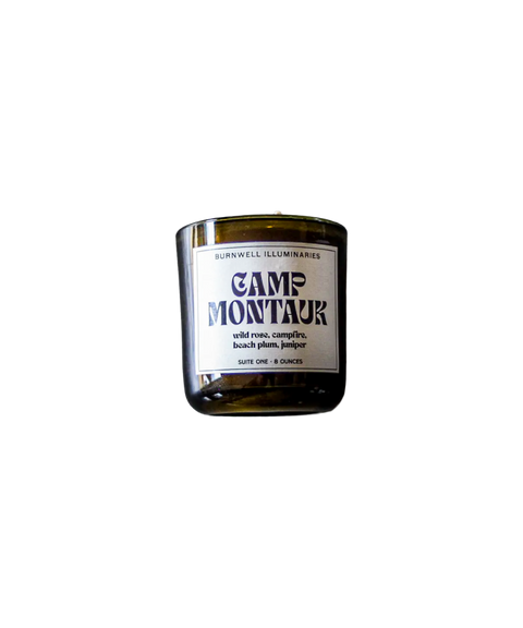 A Barnaby Black Burnwell Illuminaries Camp Montauk candle in an amber glass jar.