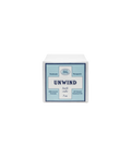 Baudelaire Unwind bath cube in a white package with a blue label, indicating natural ingredients.