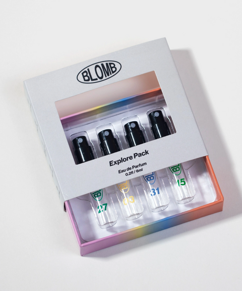 A BLOMB Explore Pack four perfume sample vials being pulled out of their box.