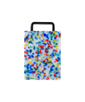 A rectangular plastic cutting board with a black metal handle, featuring a white base covered in dense multicolored confetti-like speckles in blue, red, yellow, and green, shown on a plain white background.