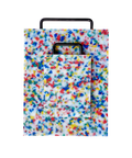 A rectangular plastic cutting board with a black metal handle, featuring a white base covered in dense multicolored confetti-like speckles in blue, red, yellow, and green, shown on a plain white background. There is a smaller matching version of the same cutting board on top of the larger one.