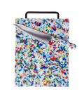 A rectangular cutting board with a multicolor speckled pattern on a white base, featuring a black handle and shown with a stainless steel chef's knife on top, isolated on a white background.