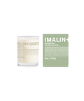 A Malin+Goetz Bergamot candle in a clear glass jar next to its mint green box.