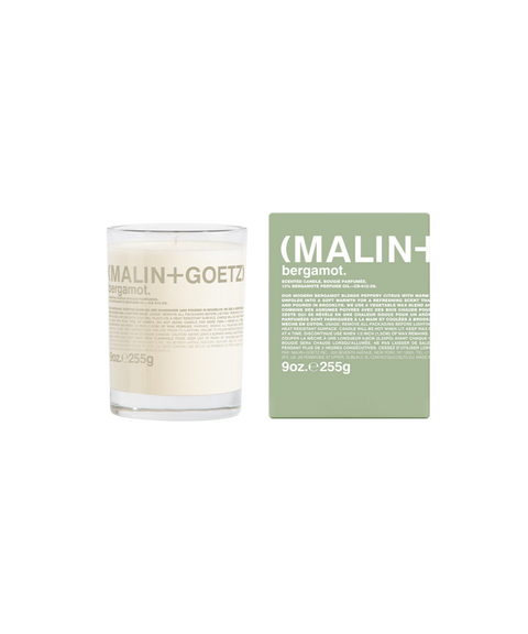 A Malin+Goetz Bergamot candle in a clear glass jar next to its mint green box.