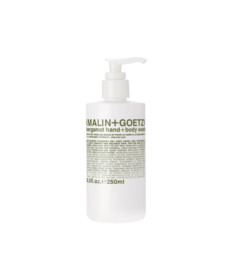 A white pump bottle of Malin + Goetz bergamot hand and body wash with green text on the label.
