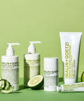 A set of Malin + Goetz skincare products arranged on a light green surface against a matching green background. 