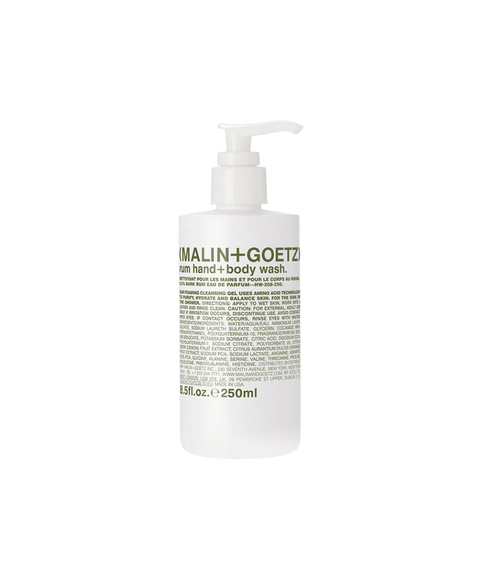 A white pump bottle of Malin + Goetz rum hand and body wash with green text on the label.