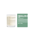 A Malin+Goetz Sage candle in a clear glass jar next to its mint green box.