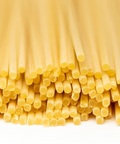 Close-up of uncooked spaghetti pasta on a white background.