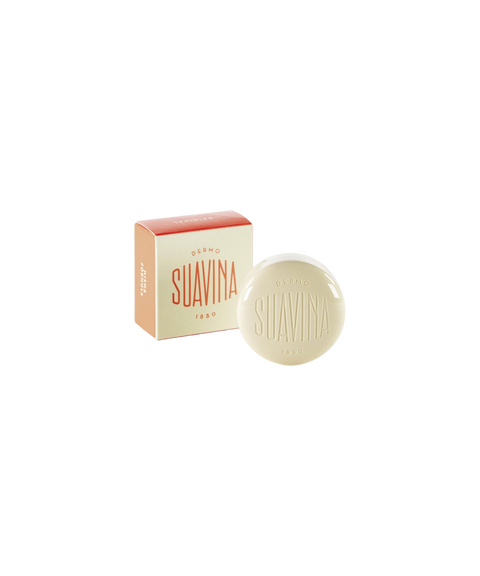 A round cream-colored pot of Suavina original lip balm next to its coral and cream packaging box.