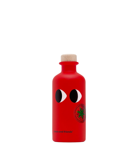 A red bottle of Yiayia & Friends tomato olive oil with cartoon eyes and a wood top.